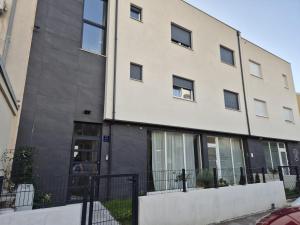 an apartment building with a black fence in front of it at Apartman Malomi in Solin