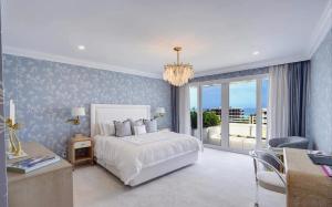 Un dormitorio con una cama blanca y un escritorio y una ventana. en Luxury Three Bedroom Oceanfront Penthouse with Terrace, en Palm Beach