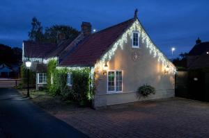 ein weißes Haus mit Weihnachtsbeleuchtung darauf in der Unterkunft Rose Cottage in Nottingham