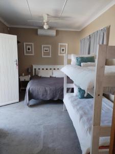 a bedroom with two bunk beds and a couch at Uitzight - Pool unit in Beaufort West