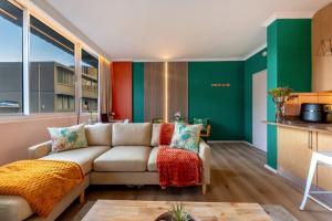 a living room with a couch and green walls at Emerald Escape With Mountain View & Pool in Cape Town