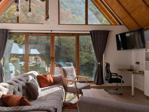 un salon avec un canapé et une grande fenêtre dans l'établissement Vila Presjenica, à Bunovci