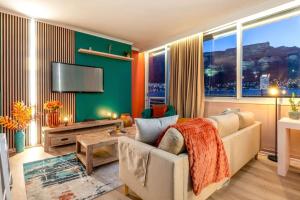 a living room with a couch and a flat screen tv at Emerald Escape With Mountain View & Pool in Cape Town