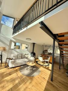 un salon avec un canapé et un escalier dans l'établissement Haus Rautenweg, à Dornbirn