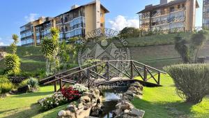 a bridge over a pond in a park with buildings at Refúgio Serrano Bananeiras in Bananeiras