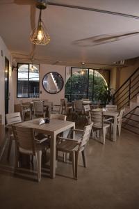 a dining room with tables and chairs and windows at History Center Hotel in Medellín