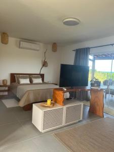 een slaapkamer met een bed en een tafel erin bij Latitude Bargada in Japaratinga