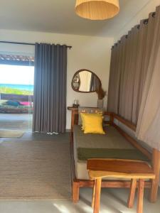 een slaapkamer met een bed met een geel kussen en een spiegel bij Latitude Bargada in Japaratinga +12 foto's