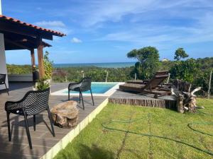 a patio with chairs and a swimming pool at Latitude Bargada in Japaratinga