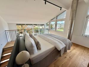 une chambre avec un grand lit et de grandes fenêtres dans l'établissement Haus Rautenweg, à Dornbirn