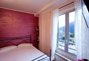 1 dormitorio con cama y ventana grande en Albergo Cecchin en Balestrino