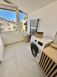 - un lave-linge et un sèche-linge dans une buanderie avec une fenêtre dans l'établissement Haus Rautenweg, à Dornbirn