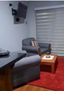 a living room with a couch and a chair and a table at Departamento N con hermosa vista al mar in Los Vilos