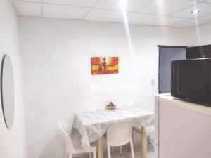 a dining room with a table and a tv at ALFA SWEET APARTS in Formosa