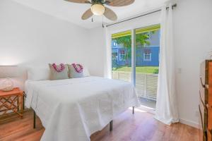 プリンスビルにあるKa Pu'uwai at Nihilani 29Bのベッドと窓のある白い寝室 +33枚の写真