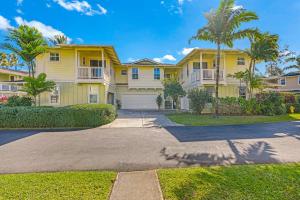 プリンスビルにあるKa Pu'uwai at Nihilani 29Bのヤシの木と私道のある大きな黄色の家