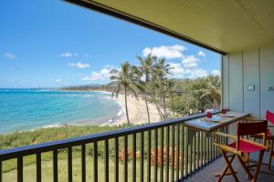 a balcony with a table and chairs and a beach at Wailua Bay View 206 in Wailua
