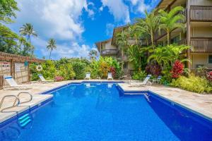 a swimming pool with chairs next to a building at Wailua Bay View 206 in Wailua