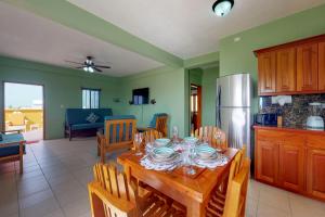 サン・ペドロにあるHanna Suite #9 at Laguna Suite -Gold Standard Certifiedのテーブルと冷蔵庫のあるキッチンとダイニングルーム