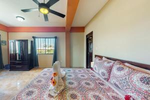 サン・ペドロにあるEastern #8 at Laguna Suite -Gold Standard Certifiedのベッドと天井扇風機のある寝室