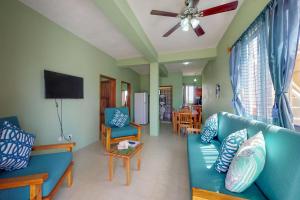 サン・ペドロにあるSara Suite #10 at Laguna Suite -Gold Standard Certifiedの青いソファと薄型テレビのあるリビングルーム
