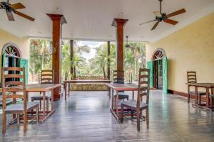 a dining room with tables and chairs and windows at Monkey Suite at Mahogany Hall -Gold Standard Certified in Bullet Tree Falls