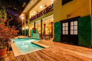 a house with a swimming pool and a wooden deck at Monkey Room at Mahogany Hall -Gold Standard Certified in Bullet Tree Falls +19 photos