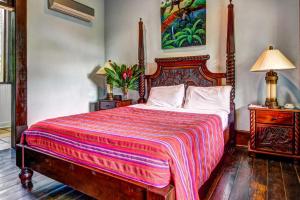 a bedroom with a large bed with a colorful blanket at Monkey Room at Mahogany Hall -Gold Standard Certified in Bullet Tree Falls