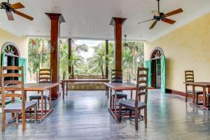a dining room with tables and chairs and windows at Monkey Room at Mahogany Hall -Gold Standard Certified in Bullet Tree Falls