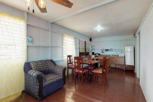 a living room with a couch and a table and chairs at Permit at Carol's Cabanas -Gold Standard Certified in Placencia Village