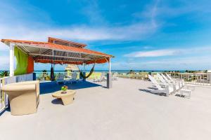 サン・ペドロにあるNorthern #2 at Laguna Suite -Gold Standard Certifiedのビーチにある椅子とパビリオンのあるデッキ