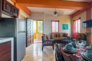 サン・ペドロにあるSouthern #5 at Laguna Suite -Gold Standard Certifiedのテーブルと冷蔵庫のあるキッチンとリビングルーム