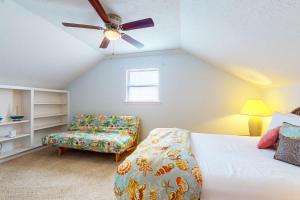 a bedroom with a bed and a chair and a ceiling fan at Ocean View 5BR l Steps to Beach l Pet-Friendly in Bolivar Peninsula