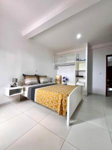a bedroom with a bed with a yellow and black bedspread at Oásis de retour in Ponta do Sol