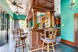 a kitchen with a bar with two chairs at Parrot Room at Mahogany Hall -Gold Standard Certified in Bullet Tree Falls +17 photos