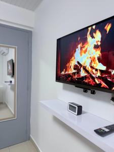 TV de pantalla plana en un estante blanco en Smylie home, en Fort-de-France