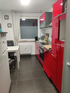 a kitchen with red cabinets and a table in it at Einzelzimmer in einer Zweier-Wohngemeinschaft in Bückeburg