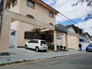 a white car parked in front of a building at Hotel Brooklin in Sao Paulo
