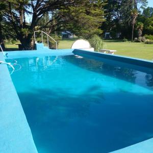 een groot zwembad met blauw water bij POSADA EL ROMANCE in Tandil