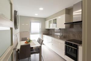 a kitchen with white cabinets and a table with chairs at El Sol in Monreal del Campo