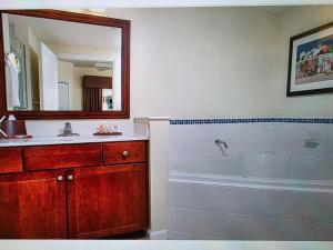 a bathroom with a tub and a sink and a mirror at Club Wyndham Oceanside Pier in Oceanside