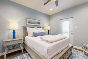 a bedroom with a bed and two lamps and a window at Retreat Gulf Views Large Deck Group Ready in Red Fish Cove