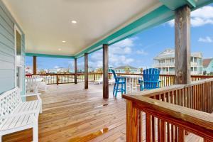 a porch with two blue chairs and a view of the ocean at Retreat Gulf Views Large Deck Group Ready in Red Fish Cove