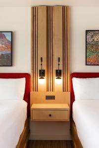 a room with two beds and a nightstand between them at El Bonita Motel in St. Helena