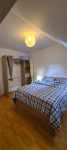 een slaapkamer met een bed met een blauwe plaids bij Jolie maison de location avec terrasse couverte et parking privé in Douarnenez