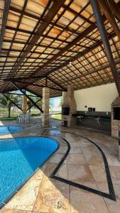 una piscina al aire libre con un gran techo de madera en Casa Stilo, en Aquiraz
