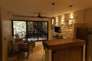 Una cocina y una sala de estar con una mesa y un sofá. en Chen Luum Residences - Departamentos de lujo en Luum Zama, en Tulum