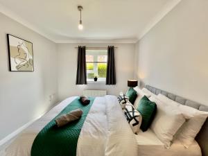 um quarto com uma cama grande e almofadas verdes e brancas em Stylish City Apartment with Free Parking near Town em Glasgow