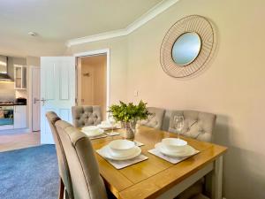 uma sala de jantar com uma mesa com cadeiras e um espelho em Stylish City Apartment with Free Parking near Town em Glasgow