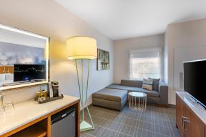a living room with a couch and a television at Cambria Hotel LAX in El Segundo